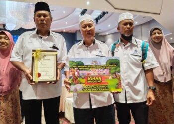 RAHIM Haron (tengah) menunjukkan hadiah kemenangan sempena Majlis Penyampaian Hadiah Pertandingan Kebersihan dan Keindahan Peringkat Negeri di sebuah hotel di Melaka. - UTUSAN/MUHAMMAD SHAHIZAM TAZALI
