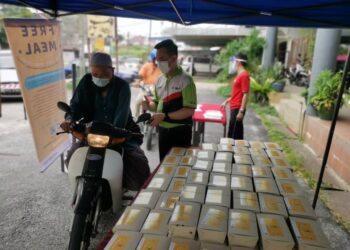 AGIHAN nasi bungkus kepada orang ramai dibuat secara pandu lalu di depan restoran Sri Cheng Mai, Jalan Sri Cemerlang, Kota Bharu hari ini. - UTUSAN/ROSALWANI CHE SOH