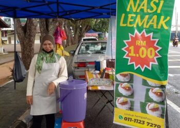 NORATI Yunus menunggu pelanggan  membeli  nasi lemak RM1 sebungkus di tepi Jalan Klebang, Melaka. – UTUSAN/AMRAN MULUP