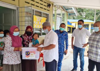 AHMAD Nazlan Idris  menyampaikan bantuan barang keperluan dapur kepada seorang mangsa banjir di Kampung Lata Kasah di Jerantut, Pahang, hari ini. - FOTO/HARIS FADILAH AHMAD