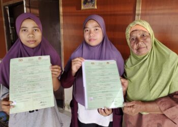 TERMAH Kasim (kanan) Siti Nur Nilam Sari (kiri) dan Siti Nur Shakila menunjukkan sijil kelahiran mereka tanpa status warganegara di Lubuk China, Negeri Sembilan, semalam. – MINGGUAN/NOR AINNA HAMZAH