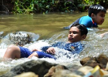 DUA kanak-kanak menyejukkan badan di Sungai Taman Rimba Templer, Rawang, Selangor ekoran cuaca panas yang melanda negara ketika ini. - UTUSAN/SYAKIR RADIN