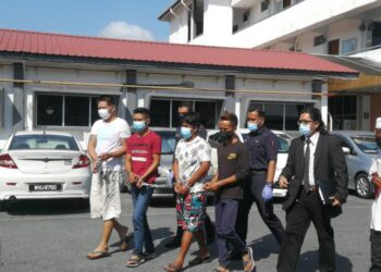 SEORANG nelayan (tiga dari kiri) dan seorang lelaki (baju merah) yang ditumbuk selepas didakwa bersama isteri nelayan tersebut dibawa keluar daripada Mahkamah Kangar, Perlis, hari ini selepas mendapat perintah reman.- UTUSAN/NAZLINA NADZARI