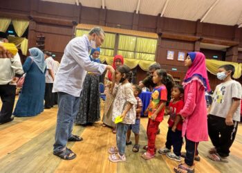 AZLAN Man memberi duit raya kepada kanak-kanak pada majlis Aidilfitri Menteri Besar di Dewan Warisan, Kangar, Perlis, hari ini. - UTUSAN/MOHD. HAFIZ ABD. MUTALIB