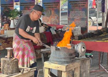 MOHD Zaki Husain membakar ketuhar arang bagi penghasilan senjata tradisional di Festival Silang Budaya Kelantan-Perlis di Dataran Dato’ Sheikh Ahmad, Kangar, Perlis, semalam. – UTUSAN/ASYRAF MUHAMMAD