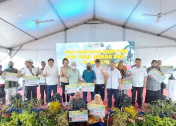NGA Kor Ming (lima dari kanan) bersama penerima bantuan baik pulih rumah daif pada  Program Fiesta Teluk Intan: Komuniti Bandar Dekat Dihati di Dataran Menara Condong Teluk Intan hari ini. - UTUSAN/AIN SAFRE BIDIN