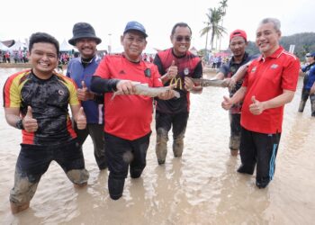 AMINUDDIN Harun (tiga dari kiri) dan Saari Abdullah (kanan) mengoca ikan pada program Pesta Tarik Tali Ngoca sempena Sambutan Hari Air Sedunia 2022 Peringkat Negeri Sembilan di Tapak Ngoca, Perkampungan Budaya Terachi, Kuala Pilah hari ini. - UTUSAN/MOHD. SHAHJEHAN MAAMIN