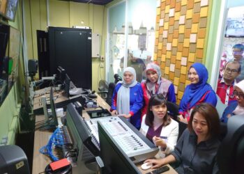 TEO NIE CHING (duduk kiri) mendengar taklimat operasi bilik suntingan ketika melawat RTM Johor di Johor Bahru.
