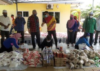 NOH Omar bertanya khabar kepada seorang penduduk di Kampung Haji Razali, Siti Aisah Kadiran (bertudung coklat) ketika mengedarkan bantuan bakul makanan kepada masyarakat di Tanjung Karang, Kuala Selangor. - Utusan / MOHAMAD ATHIR ISMAIL