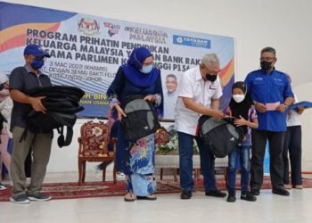 NOH Omar (tengah) menyampaikan beg sekolah ketika Majlis Penyerahan Bantuan Sekolah Yayasan Bank Rakyat Parlimen Kota Tinggi di Dewan Felda Bukit Easter, Kota Tinggi, Johor.