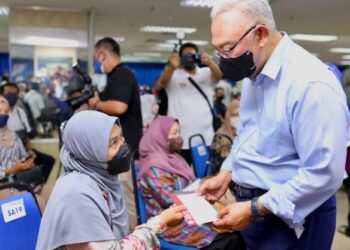 NOH Omar menyerahkan bantuan kepada seorang usahawan pada Majlis Penyerahan Bantuan Mangsa Banjir Usahawan Keluarga Malaysia di Bangunan UMNO Shah Alam, Selangor, hari ini. - FOTO/ZULFADHLI ZAKI