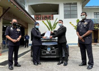 INSPEKTOR Nor Izrayasrina Muhamad Saad menyerahkan dokumen dan kunci kenderaan kepada Penolong SUK, Ahmad Zuhri Sapian sambil disaksikan Abdul Majid Mohd. Ali  (kiri) di IPK Melaka, Bukit Beruang, Melaka. - UTUSAN/DIYANATUL ATIQAH ZAKARYA