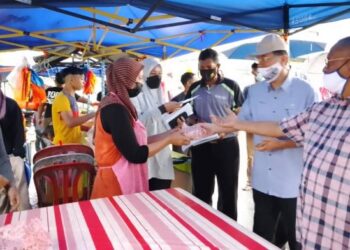 NOROLAZALI Sulaiman (dua dari kanan) bertemu dan menyampaikan sumbangan kepada peniaga yang terkesan berikutan ribut di Bazar Ramadan Triang, Bera, Pahang. - FOTO/AZIZAH SHAFIEI