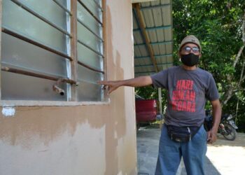 ABDUL Khalid Muhamud menunjukkan tingkap yang diumpil oleh seorang banduan untuk memasuki rumahnya dalam kejadian di Kampung Petaseh, Jelebu, Negeri Sembilan,  hari ini. - FOTO/ZAKKINA WATI AHMAD TARMIZI