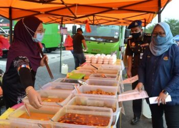 AIN Arjuna Aziz Zaman (kanan) memeriksa tanda harga sempena Op Pantau di Bazar Ramadan Sendayan Metropark, Bandar Seri Sendayan, Seremban hari ini.- FOTO/ZAKKINA WATI AHMAD TARMIZI