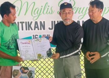 BAKRI Sawir (tengah) menyampaikan sijil pelantikan kepada salah seorang juru pandu Gua Batu Maloi sambil disaksikan Pengarah Jabatan Perhutanan Negeri Sembilan, Saleh Awaludin (kanan) di Taman Eko Rimba Batu Maloi, Kuala Pilah, hari ini. - FOTO/AFIFI HAFIZ MOHD. NOR