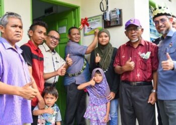 AMINUDDIN Harun (enam dari kiri) merasmikan salah satu unit Rumah Baitul Rahmah yang telah siap dibina di Kampung Orang Asli Panchor, Jempol, semalam.