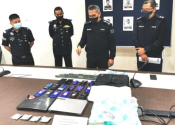 MOHAMAD Mat Yusop (dua dari kanan) menunjukkan hasil rampasan pihak polis susulan penahanan enam orang berkaitan pelaburan tidak wujud dalam sidang akhbar di IPD Nilai, Seremban hari ini. - FOTO/AFIFI HAFIZ MOHD.