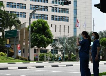 GAMBAR fail kakitangan kesihatan di luar Hospital Tan Tock Seng. - AFP