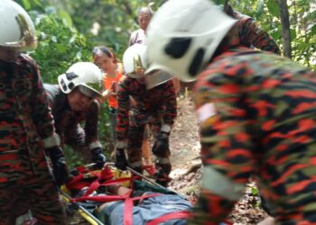 LAPAN anggota bomba membawa turun seorang lelaki berusia 44 tahun yang patah kaki selepas tergelincir di Bukit 300 Teluk Batik, dekat Lumut, hari ini. - UTUSAN/JBPM PERAK