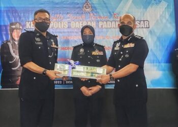 MOHD. Shokri Abdullah (kanan) menerima cenderamata daripada Saifudin Aslin Abbas sambil disaksikan Surina Saad dalam majlis serah terima tugas Ketua Polis Daerah Padang Besar yang baharu di IPD Padang Besar, Perlis hari ini.- UTUSAN/SYED AZLAN SAYID HIZAR