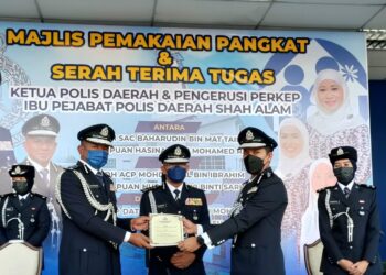 ARJUNAIDI Mohamed (tengah) menyaksikan penyerahan dokumen serah tugas antara Baharudin (kiri) dan Mohd. Iqbal Ibrahim dalam majlis pemakaian pangkat serta serah tugas di IPD Shah Alam, Selangor, hari ini.