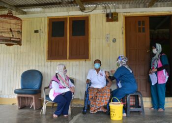 MAT Soh Mat San yang kudung kaki kanan menerima suntikan Covid-19 dalam program outreach vaksin di rumahnya di Kampung Baru Pulau Redang, Kuala Nerus semalam. - PUQTRA HAIRRY ROSLI
