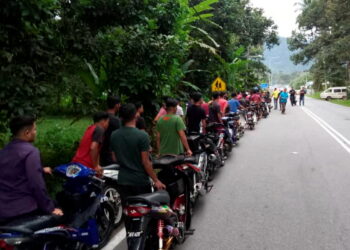SEBAHAGIAN penunggang yang ditahan dalam Op Samseng Jalanan menolak motosikal masing-masing ke Balai Polis Batu Kurau, Taiping, Perak, semalam.- IHSAN  PDRM