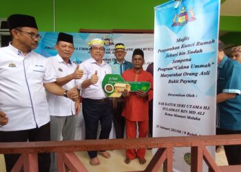 Sulaiman Md. Ali menyerahkan replika kunci rumah baharu kepada Johari Sudah selepas Program Program Cakna Ummah Masyarakat Orang Asli Bukit Payung, Alor Gajah, Melaka. UTUSAN/AMRAN MULUP.