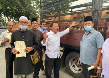 OSMAN Sapian menyerahkan lembu korban di Taman Bukit Kempas, Johor Bharu hari ini. - UTUSAN/ Juani Munir Abu Bakar