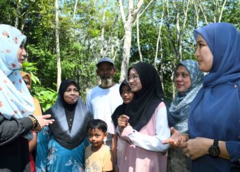 KHARTINA Musaddiq (kiri) mengunjungi dan memberi penerangan peluang yang ditawarkan untuk menyambung pelajaran kepada Nur Alia Maisarah Abdullah (empat dari kanan) iaitu anak seorang penoreh getah yang memperoleh keputusan 9A SPM di Kampung Kubang Perun, Chuping, Padang Besar, UTUSAN/IZLIZAN OTHMAN/
