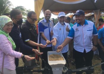 K. NAGELENDRAN (tiga dari kanan) menunjukkan benih padi IS21 pada Majlis Penyerahan Benih Padi IS21 kepada pesawah Pertubuhan Peladang kawasan Machang di Unit Peladang, Kampung Bukit Tiu, Machang, Kelantan hari ini. -UTUSAN/ROSMIZAN RESDI