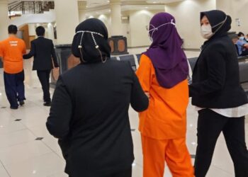DUA kakitangan Paip (baju oren) dibawa keluar selepas permohonan reman selesai di Mahkamah Majistret Kuantan di, Pahang. - UTUSAN/DIANA SURYA ABD WAHAB