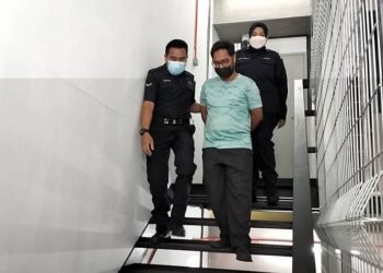 MUHAMAD Syazwanuddin Sahimi (tengah) didakwa di atas 57 pertuduhan memalsukan dokumen di Mahkamah Sesyen Ipoh hari ini. - UTUSAN/ASLIZA MUSA