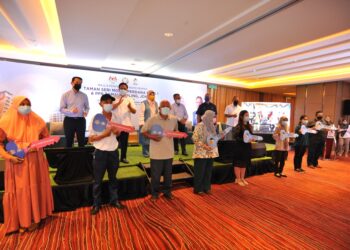 ZURAIDA Kamaruddin (belakang, tiga dari kiri) bergambar bersama penerima kunci rumah sempena Majlis Penyerahan Kunci Rumah Taman Seri Molek Perdana Fasa 1 dan PPR Taman Perling di Hotel DoubleTree By Hilton, Johor. - UTUSAN/RAJA JAAFAR ALI