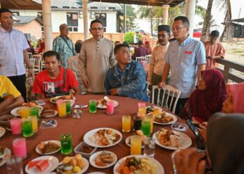 NIK Nazmi Nik Ahmad (berdiri, kanan) beramah mesra dengan golongan asnaf pada Majlis Iftar  di Kuala Terengganu, malam ini. - UTUSAN/PUQTRA HAIRRY ROSLI  