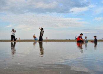 PENGUNJUNG termasuk kanak-kanak tidak melepaskan peluang bersantai dan mengambil gambar di Pantai Pandak terutama dengan keunikan terbaharu pantai cermin di lokasi berkenaan semasa tinjauan di Kuala Terengganu, semalam. - PUQTRA HAIRRY ROSLI