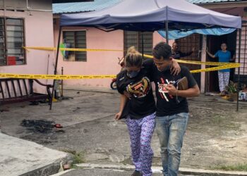 IBU mangsa dipapah  selepas cedera pada kaki ketika cuba memadam api kebakaran yang mengorbankan dua anak mereka dalam kebakaran di Kampung Dato' Sulaiman Menteri, Johor Bahru