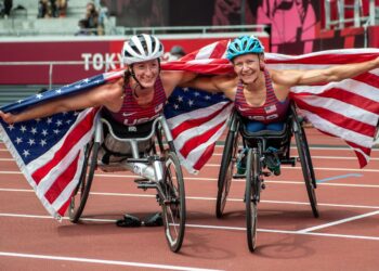 TATYANA McFadden (kiri) meraikan kejayaan meraih gangsa bersama rakan senegara yang juga pemenang pingat emas 5,000 meter T53/54 wanita pada Sukan Paralimpik Tokyo 2020, Susannah Scaroni. – AFP