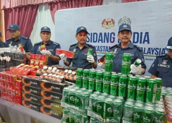 SAZALI MOHAMAD (tengah) menunjukkan sebahagian daripada rampasan rokok dan arak dalam sidang akhbar di Ibu pejabat Kastam Johor, Johor Bahru.