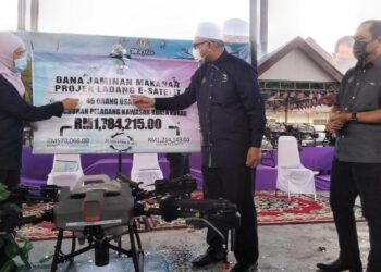 RAZMAN Zakaria (tengah) pada program penyerahan dron dan sumbangan MAFI Prihatin di Kuala Kurau dekat Bagan Serai hari ini. - UTUSAN/WAT KAMAL ABAS