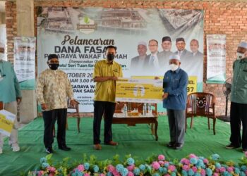 TUAN Ibrahim Tuan Man (dua dari kanan) menerima replika cek wakaf yang disumbangkan dalam majlis di tapak Pasaraya Wakaf Ummah, Dungun, Terengganu, semalam. - FOTO/PUQTRA HAIRRY ROSLI