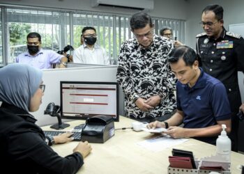 SAIFUDDIN Nasution Ismail meluangkan masa bersama pegawai JIM selepas merasmikan Pejabat Pasport KLIA di Sepang, Selangor. - UTUSAN/FAIZ ALIF AHMAD ZUBIR/PEMBERITA - AMREE AHMAD