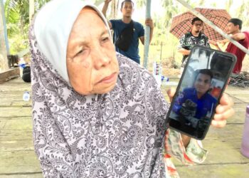NORIAH Awang menunjukkan gambar anaknya yang maut di patuk ular tedung di Kampung Kemasin Bachok Kelantan, semalam. 
– UTUSAN/ROSLIZA MOHAMED