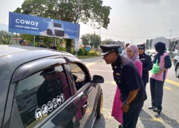 MOHD. Khaizam Ahmad Shahabudin mengedarkan bubur lambuk kepada pengguna jalan raya sempena program Semarak Kasih Ramadan di Sungai Siput hari ini. - UTUSAN