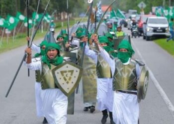 SEBAHAGIAN peserta program Himpit 2023 berarak membawa replika pedang, perisai dan lembing di Setiu, Terengganu. - GAMBAR MEDIA SOSIAL