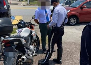 POLIS daripada Bahagian Siasatan dan Penguatkuasaan Trafik IPD Johor Bahru Selatan membuat pemeriksaan ke atas motosikal dinaiki pelajar dalam Op Didik di SMK Taman Damansara Alif, Johor Bahru semalam. - FOTO/MOHAMAD FAIZAL HASHIM
