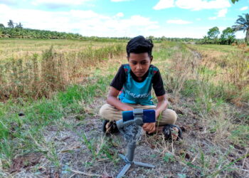 MOHD. Asrullah Zahari terpaksa mengikuti PdPR di sawah berikutan capaian internet rendah di Seberang Perak, Pasir Salak. – UTUSAN/MOHAMAD HAFIZI MOHD. SAID