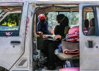 Nurul Asyikin Sapuwan yang ditemani Noraishah Sulong tiba di kolej kediaman UiTM Shah Alam, Jumaat lalu untuk meneruskan pembelajaran secara bersemuka. – UTUSAN/AFIQ RAZALI