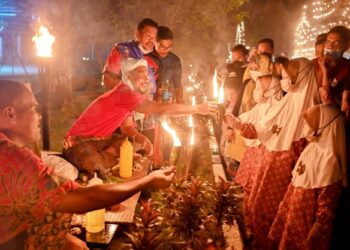 Mohd. Zailani Mohd. Nor (dua dari kiri) memberi pelita kekabu kepada orang ramai sempena program Pelita Raya Beautiful Terengganu 2022 di Kampung Budaya, Kompleks Muzium Negeri, Kuala Terengganu, semalam. – UTUSAN/PUQTRA HAIRRY ROSLI